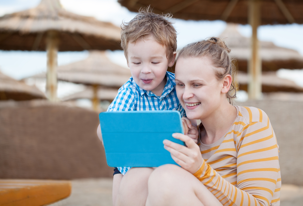 Mom and son playing games on a tablet for literacy development