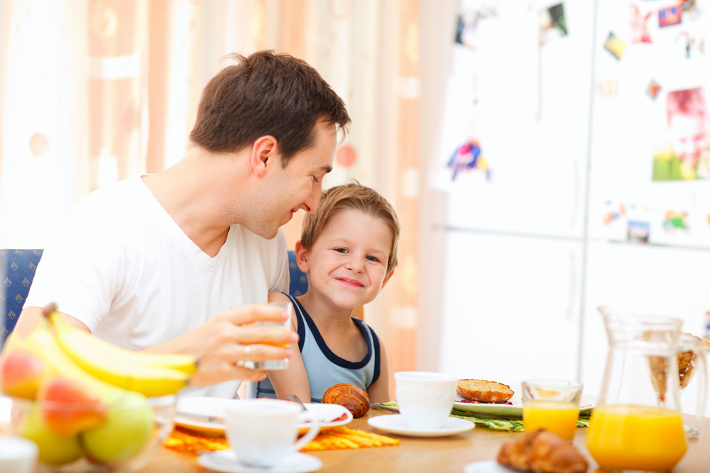 Dad and son having breakfast as part of their morning routine for school