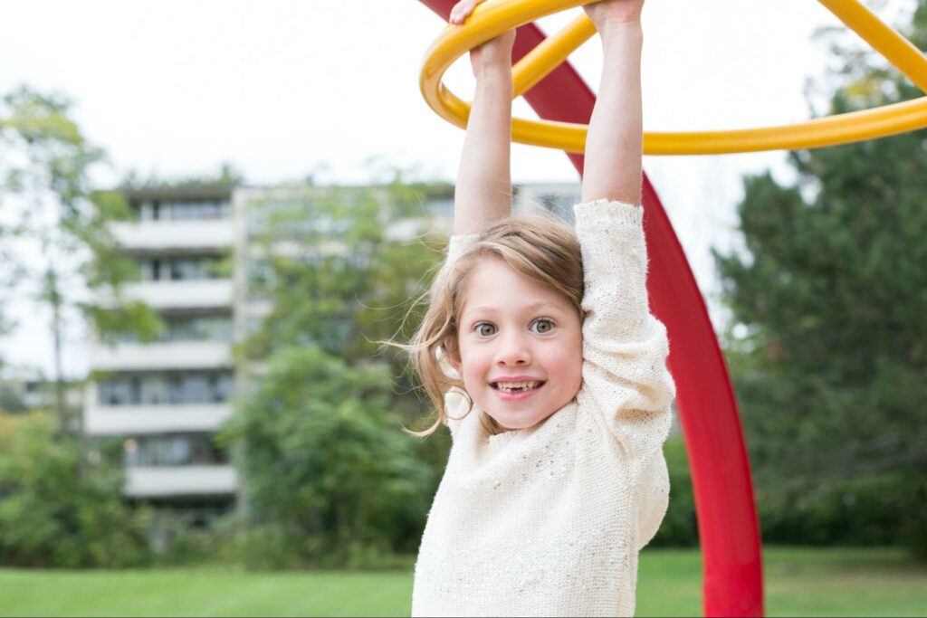 Kid hanging from monkey bars