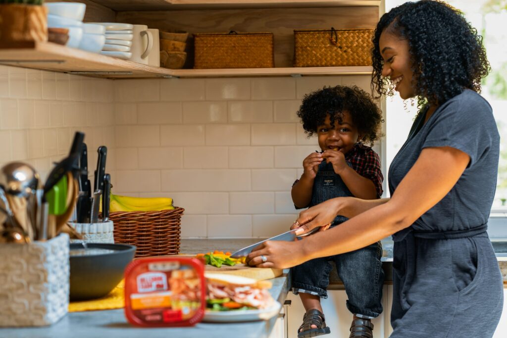 Mom cutting up veggies with son