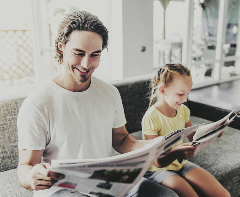 Dad and daughter reading the newspaper together