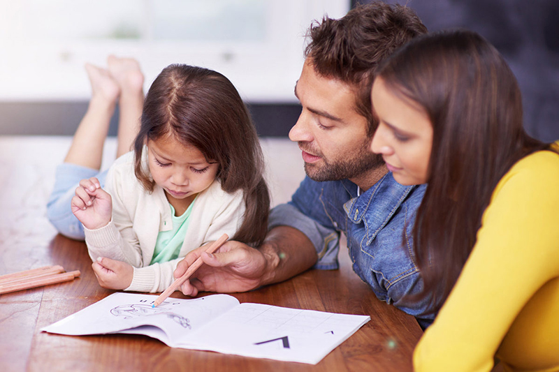 Parents doing reading strategies with young daughter 