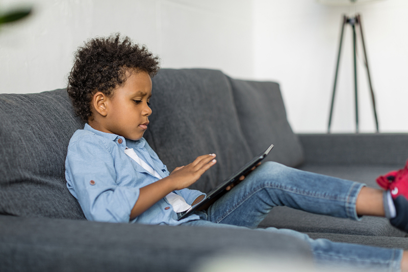 Young kid using screen time intentionally to prevent summer slide
