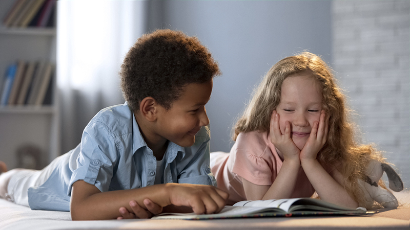 Two kids learning syllables while reading