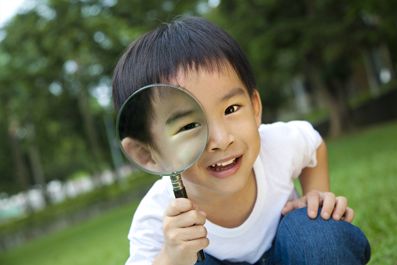 happy kid with magnifying glass