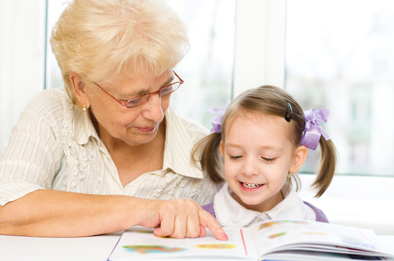 A grandmother teaching her grand daughter syllables