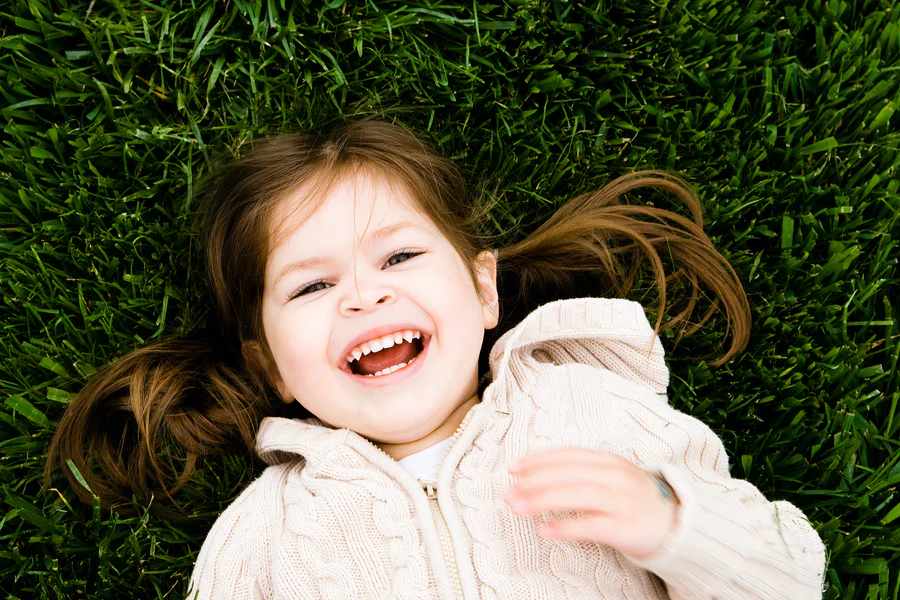 Kid on grass laughing
