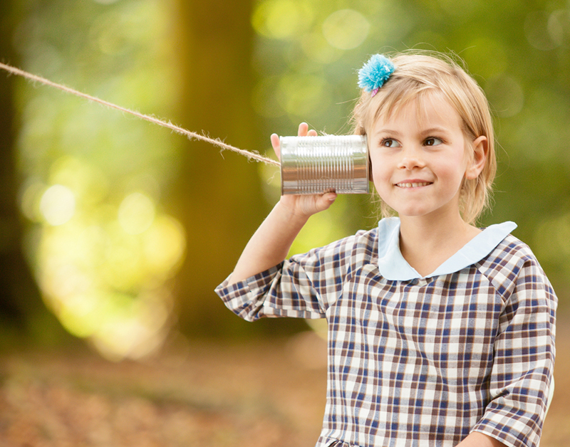 Blonde girl listening on a tin can communicator