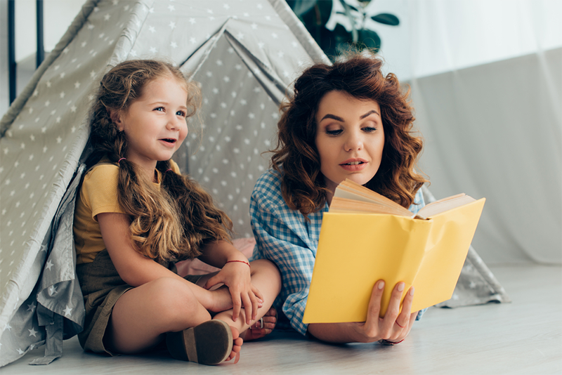 Mom reading to child in a fort