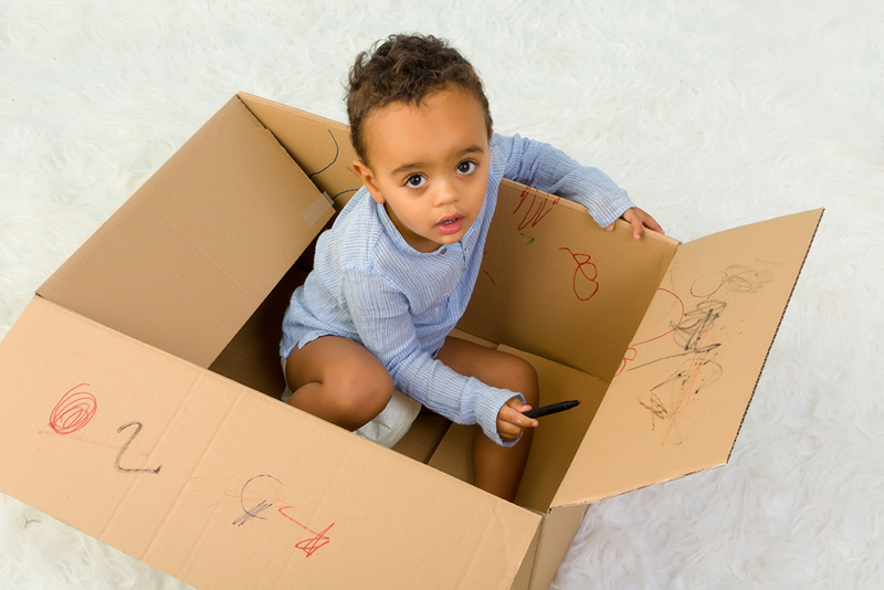 young boy playing in a box