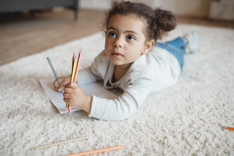 young girl writing Uppercase Letters And Lowercase Letters with colored pencils