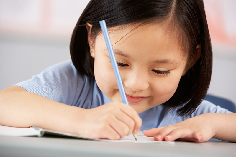 Young girl writing Uppercase Letters And Lowercase Letters