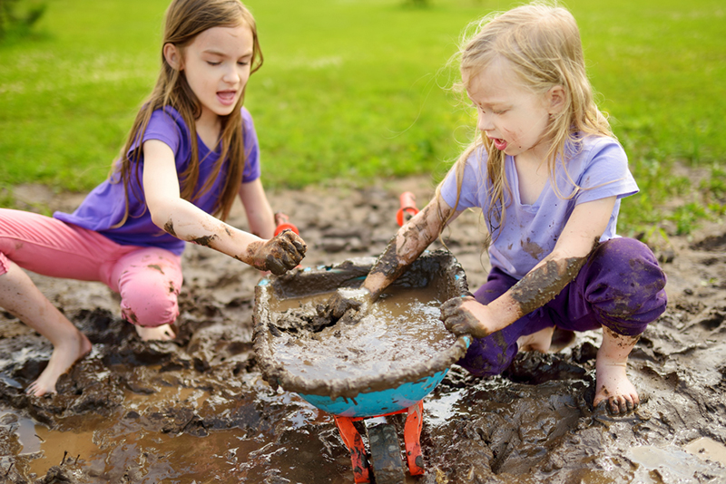 two girls playing with mud