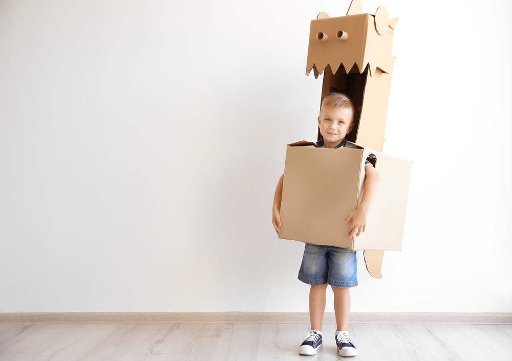 Kid playing with cardboard boxes