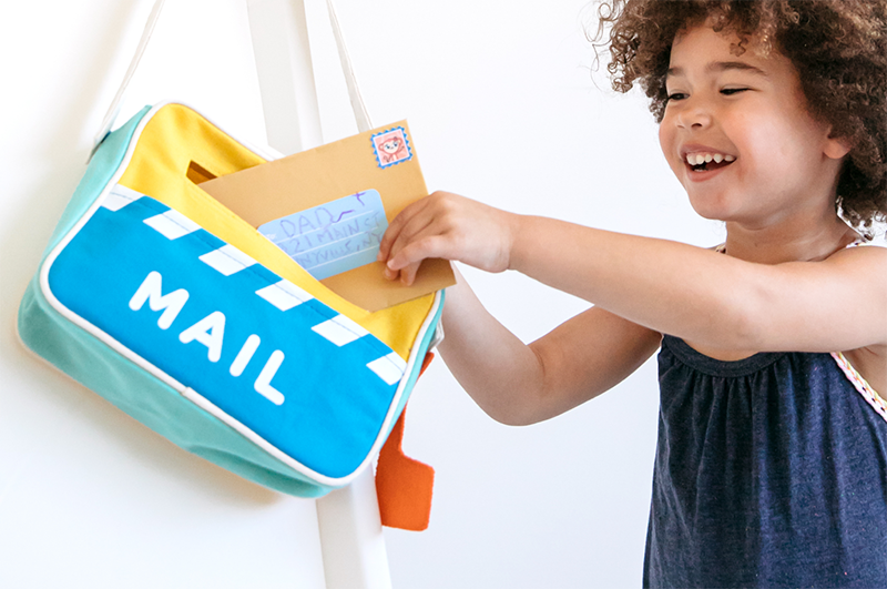 Young kid mailing letters during make-believe play 