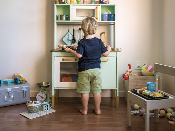Kid having make-believe play with a kitchen