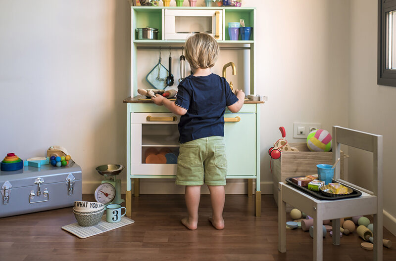 Kid having make-believe play with a kitchen