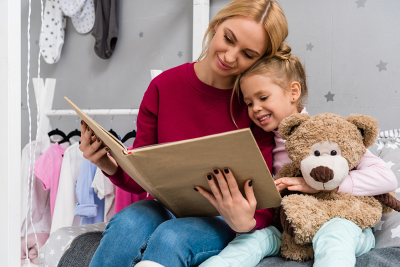 Mom helping daughter making connections while reading to her