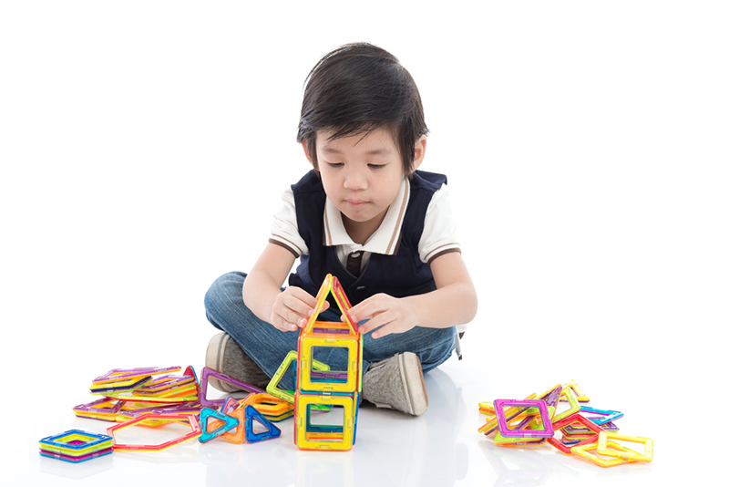 young boy playing with building toys