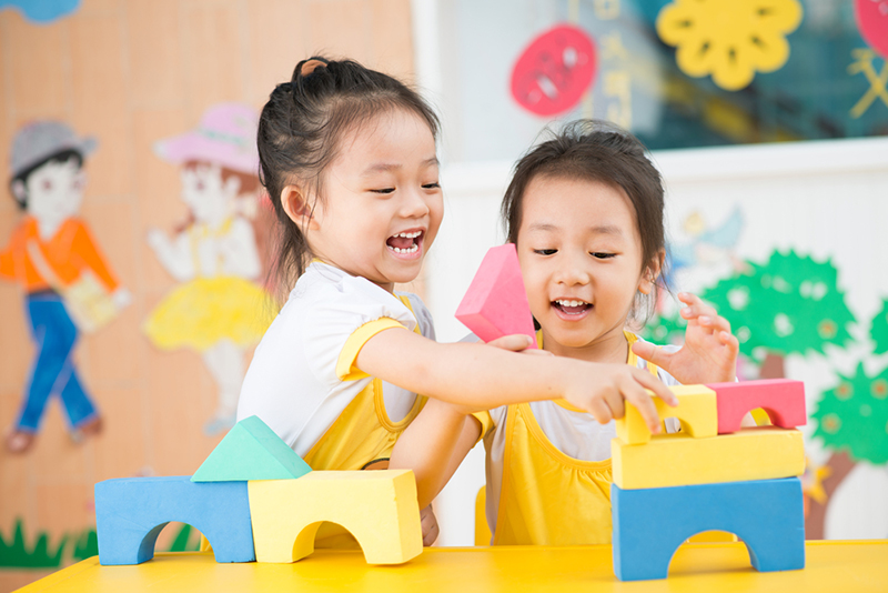 two kids playing with building blocks