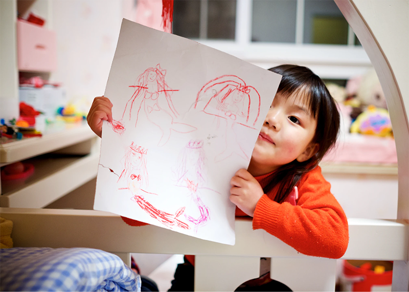 Young girl showing off her drawings