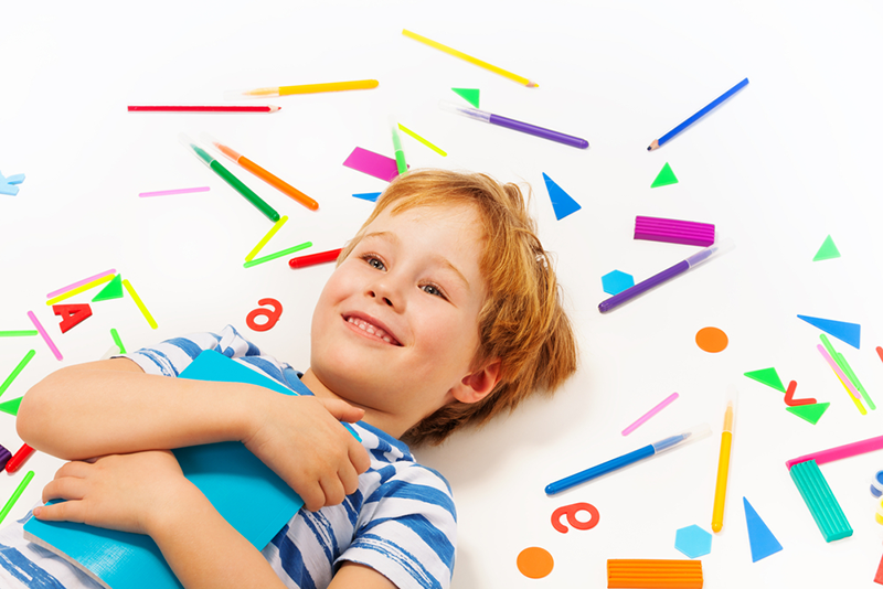 Kid laying on paper shapes 